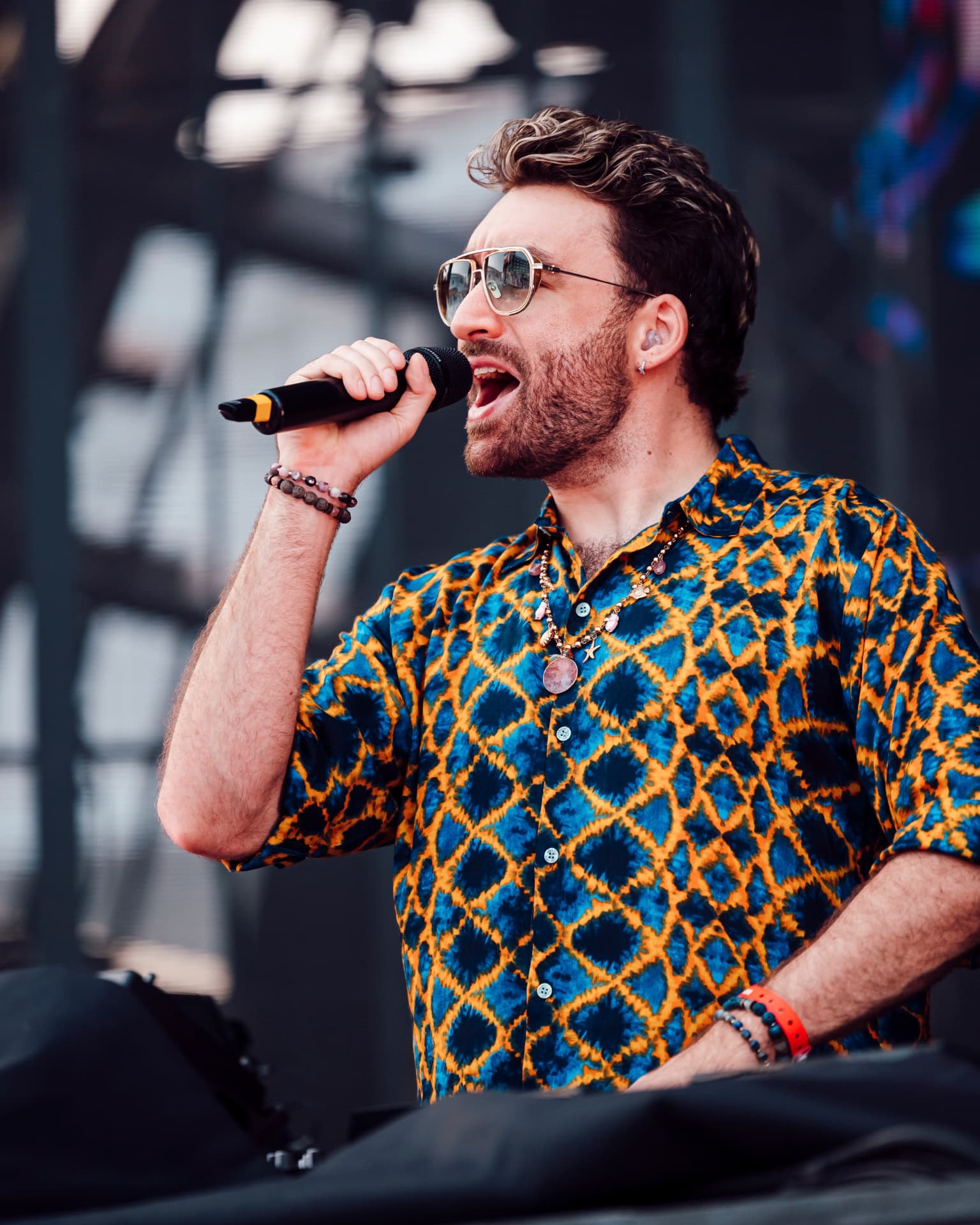Oliver Heldens s mikrofonem v profilu na pódiu